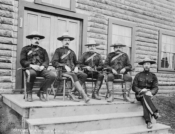 Titre original :  Officiers de la Division « B », Police à cheval du Nord-Ouest, de gauche à droite : inspecteur Wm. H Scarth; Dr Z.T. Wood; inspecteur W.H. Routledge; inspecteur Courtland Starnes; chirurgien adjoint Dr. A. Thompson. 