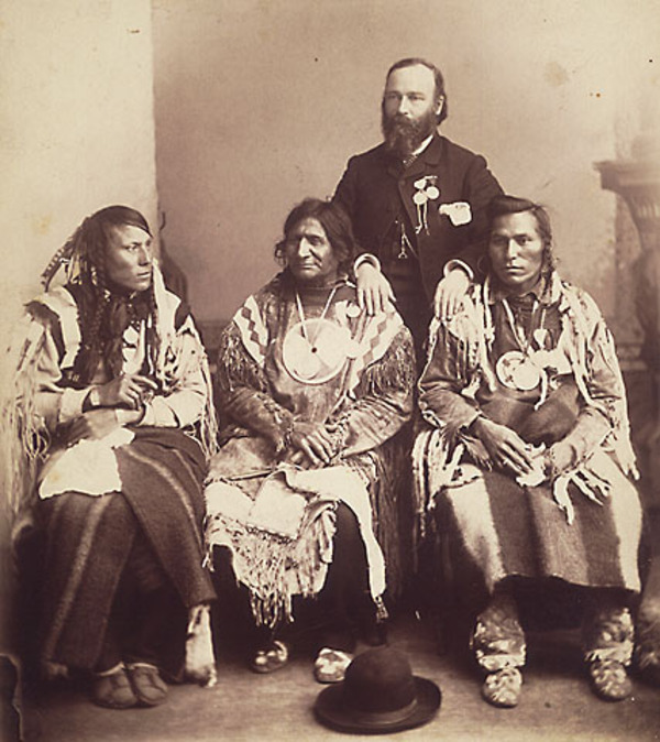 Titre original :  Chefs Pieds-Noirs et du Sang qui n'ont pas pris part à la Rébellion du Nord-Ouest de 1885 et qui ont été emmenés en Ontario par le gouvernement fédéral pour l'inauguration du monument à la mémoire de Brant. 
Sitting, left to right: One-Spot, PipeBearer of Crowfoot, Red Crow and North Axe. The interpreter is standing behind. 